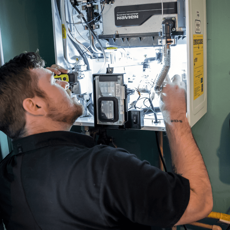 Technician repairing an open Navien tankless water heater